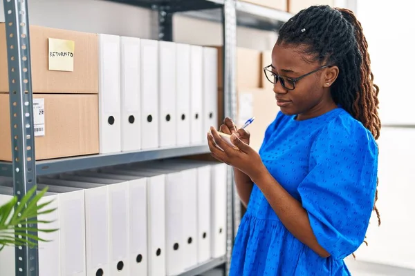 stock image African american woman business worker writing on reminder paper at office