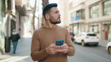 Sokakta akıllı telefon kullanan genç bir İspanyol.