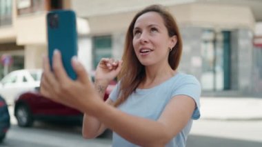 Sokakta video araması yapan kendine güvenen genç bir kadın.