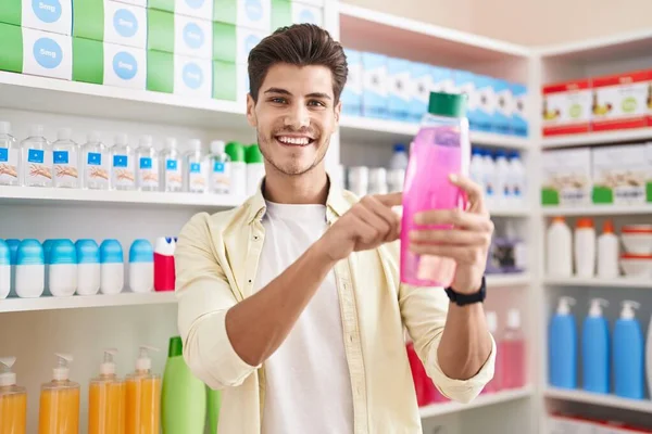 Jonge Spaanse Man Klant Glimlachend Zelfverzekerd Lezen Shampoo Fles Bij — Stockfoto