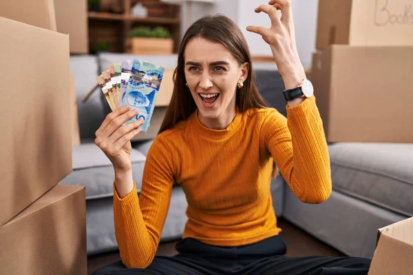 Young Caucasian Woman Sitting Floor New Home Holding Canadian Money — Stockfoto