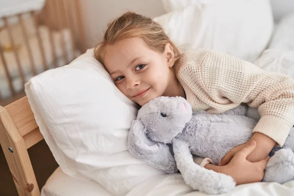 Adorable Blonde Girl Hugging Rabbit Doll Lying Bed Bedroom — Stock Photo, Image