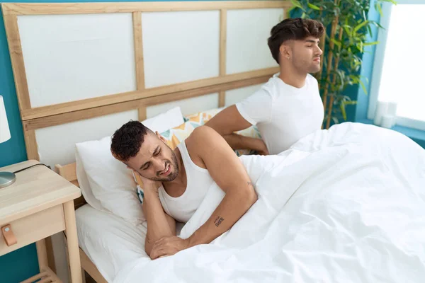 Två Latinamerikanska Män Par Lider För Ryggskada Sitter Sängen Sovrummet — Stockfoto