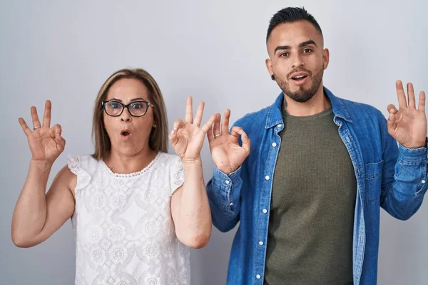 Hispanic Mor Och Son Står Tillsammans Ser Förvånad Och Chockad — Stockfoto