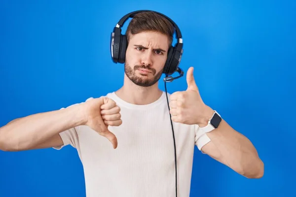 Hispanic Man Beard Listening Music Wearing Headphones Doing Thumbs Disagreement — Stockfoto