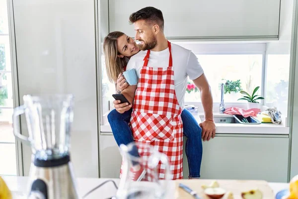 Young Couple Wearing Cook Apron Drinking Coffee Using Smartphone Kitchen — Stock Photo, Image