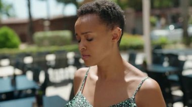 Sokakta ciddi bir ifadeyle duran Afrikalı Amerikalı kadın.