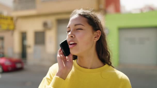 若いアフリカ系アメリカ人の女性が路上でスマートフォンで自信を持って話しています — ストック動画