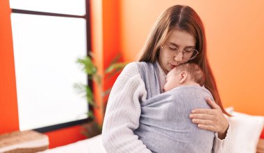 Anne ve oğul yatak odasında öpüşüp sarılıyorlar.