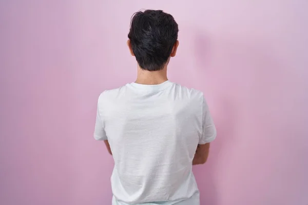 Νεαρός Ισπανόφωνος Στέκεται Πάνω Από Ροζ Φόντο Στέκεται Πίσω Κοιτάζοντας — Φωτογραφία Αρχείου