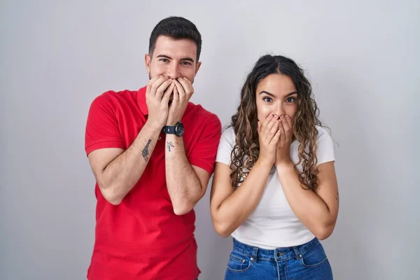 Young Hispanic Couple Standing Isolated Background Laughing Embarrassed Giggle Covering — ストック写真