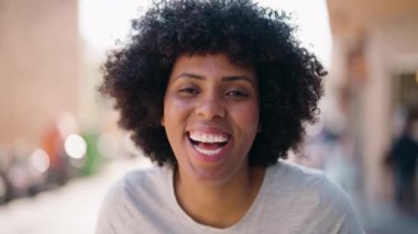 Genç Afrikalı Amerikalı kadın gülümsüyor. Kendine güveni tam.
