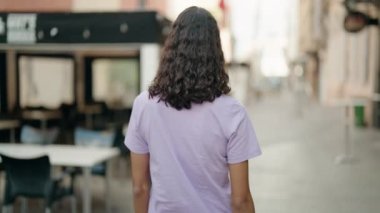 Afro-Amerikalı genç bir kadın kahvecinin terasında kendine güvenerek gülümsüyor.