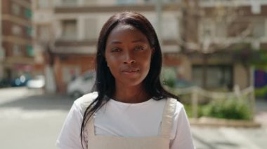 Genç Afrikalı Amerikalı kadın gülümsüyor. Kendine güveniyor. Öpüşme hareketi yapıyor.