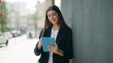 Young hispanic girl smiling confident using touchpad at street