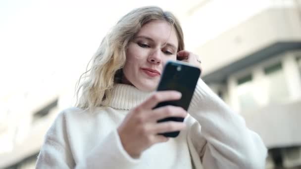 Młoda Blondynka Uśmiecha Się Pewnie Pomocą Smartfona Ulicy — Wideo stockowe
