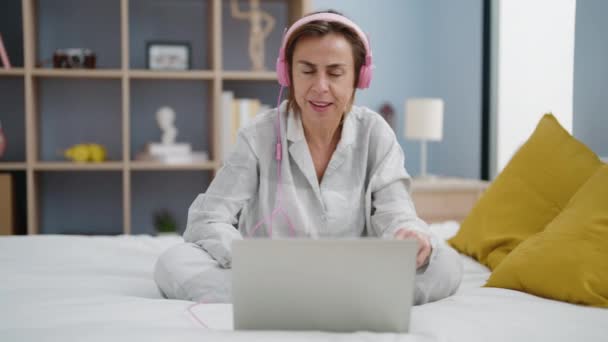 Midaldrende Kvinde Lytter Til Musik Sidder Sengen Soveværelset – Stock-video