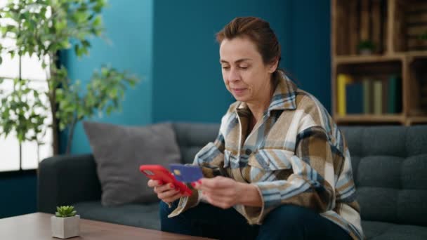 Mulher Meia Idade Usando Smartphone Cartão Crédito Sentado Sofá Casa — Vídeo de Stock