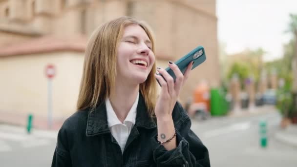 코카서스 여성은 자신있게 웃으면서 거리에서 스마트폰으로 얘기하고 있습니다 — 비디오