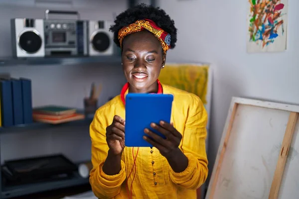 在艺术工作室 年轻的非洲裔美国女艺术家戴着耳机 带着触摸板 — 图库照片