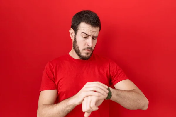 Jovem Hispânico Vestindo Casual Camiseta Vermelha Verificando Tempo Relógio Pulso — Fotografia de Stock