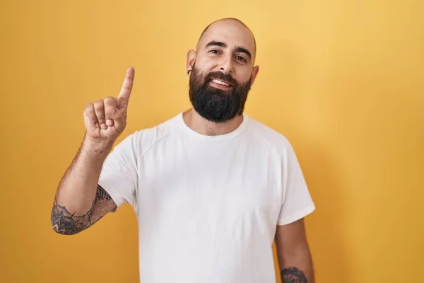 Young Hispanic Man Beard Tattoos Standing Yellow Background Showing Pointing —  Fotos de Stock