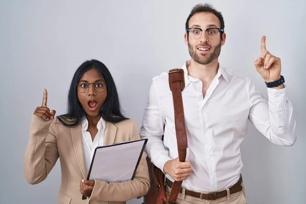 stock image Interracial business couple wearing glasses pointing finger up with successful idea. exited and happy. number one. 