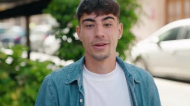 Latin asıllı genç adam gülümsüyor.