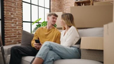 Young couple make selfie by the smarphone sitting on sofa at new home