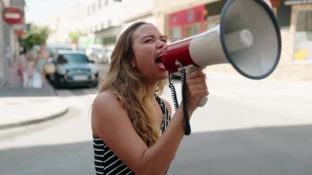 年轻美丽的惊慌失措的女人在街上用扩音器尖叫 — 图库视频影像