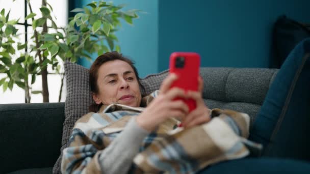 Middle Age Woman Using Smartphone Lying Sofa Home — Αρχείο Βίντεο