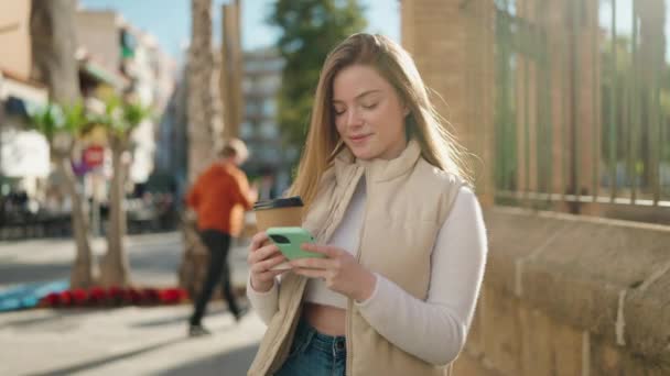 年轻的金发女人在街上用智能手机喝咖啡 — 图库视频影像