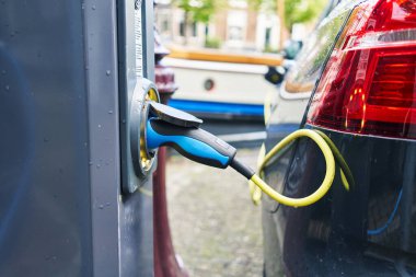 Elektrikli araba sokakta şarj oluyor.