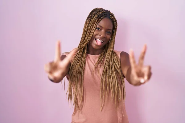 Африканская Американка Плетеными Волосами Стоящая Розовом Фоне Улыбающаяся Показывая Пальцами — стоковое фото