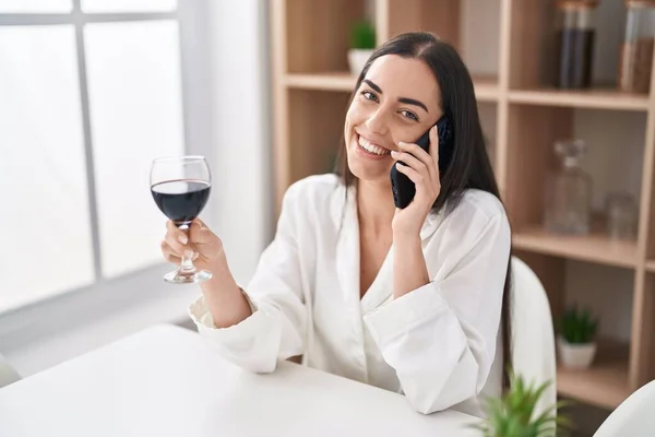 Mujer Hispana Joven Hablando Teléfono Inteligente Bebiendo Vino Casa —  Fotos de Stock