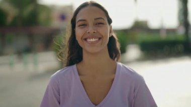 Genç Afrikalı Amerikalı kadın gülümsüyor. Kendine güveni tam.