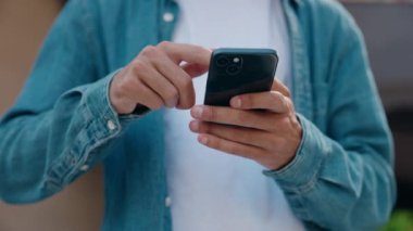 Sokakta akıllı telefon kullanan genç bir İspanyol.