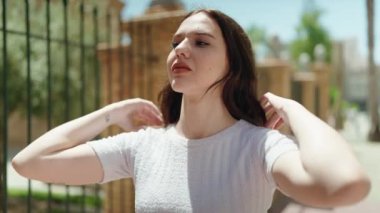 Sokakta kendinden emin gülümseyen genç bir kadın