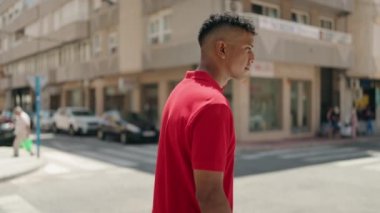 Young latin man smiling confident standing with arms crossed gesture at street
