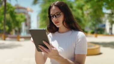 Parkta dokunmatik ped kullanan genç bir kadın.