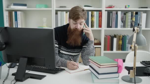 Young Redhead Man Student Talking Smartphone Writing Notebook Library University — Vídeo de stock