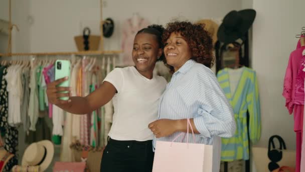 アフリカ系アメリカ人女性のお客様は衣料品店でスマホショッピングで自撮り — ストック動画
