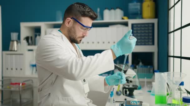 Ung Latinamerikan Man Bär Vetenskapsman Uniform Mäter Vätska Laboratoriet — Stockvideo
