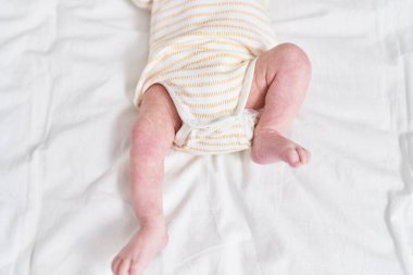 Adorable caucasian baby lying on bed at bedroom