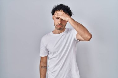 Hispanic man standing over isolated background worried and stressed about a problem with hand on forehead, nervous and anxious for crisis 