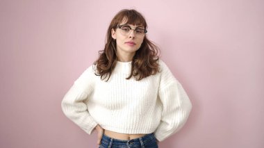 Young caucasian woman standing with serious expression over isolated pink background