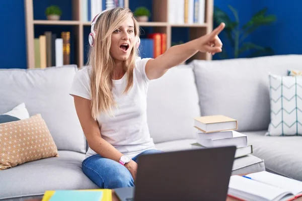 Young Blonde Woman Studying Using Computer Laptop Home Pointing Finger — ストック写真
