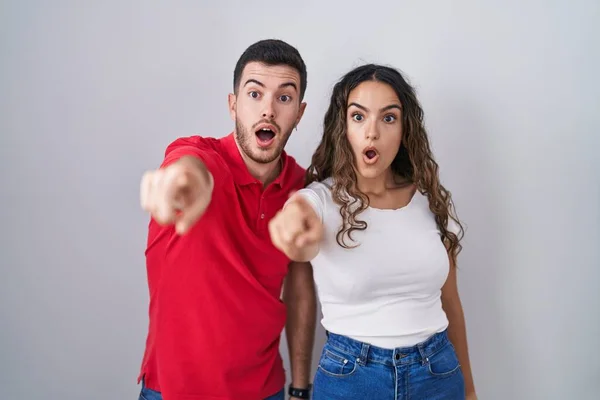 Young Hispanic Couple Standing Isolated Background Pointing Finger Surprised Ahead — Fotografia de Stock