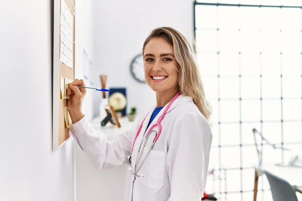 Young Woman Wearing Doctor Uniform Writing Corkboard Clinic — Stock Photo, Image