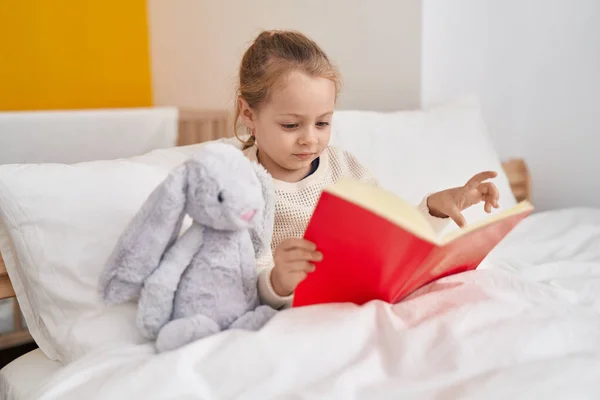 Adorable Blonde Girl Reading Book Sitting Bed Bedroom — Stok fotoğraf
